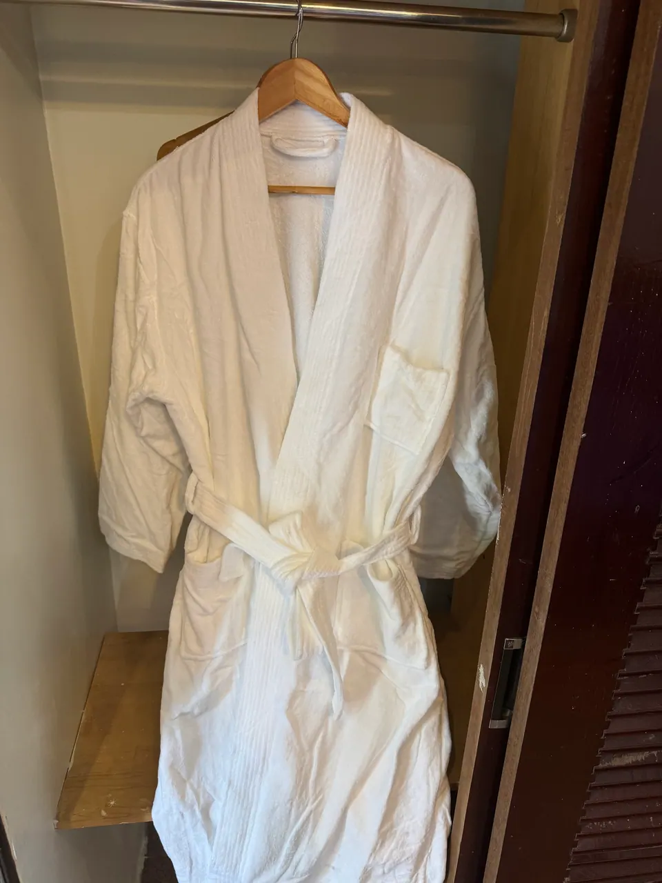 Soft white bathrobe hanging by the door