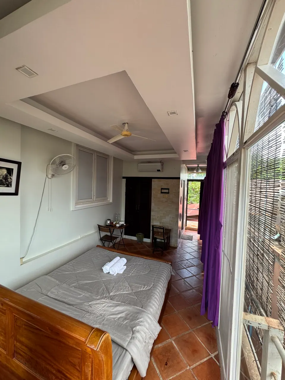 Special queen room with tall windows and bamboo blinds